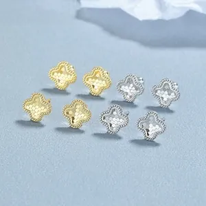 Detail view of gold and silver four-leaf clover earrings with beaded edge texture