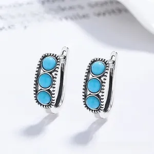 Detail view of 925 silver retro stud earrings featuring turquoise inlay and beaded edges