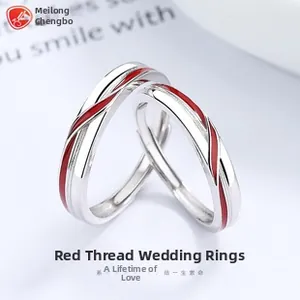 Dettaglio macro di anelli di coppia regolabili in argento con linea di smalto rosso minimal