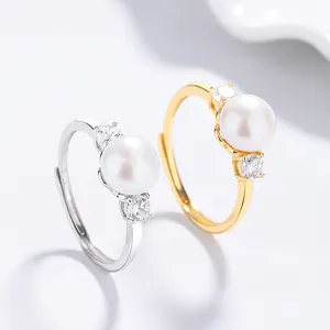 Ensemble de bagues en perles d'eau douce or et argent avec zircons sur fond épuré