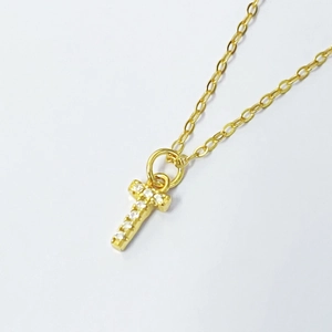 Close-up of gold S925 silver necklace with micro pavé cubic zirconia letter T pendant