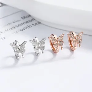Macro shot of 925 silver and rose gold butterfly earrings with zircon micro-pave details