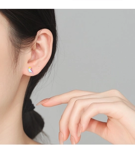 Detailed view of colorful enamel bird stud earring in 999 silver worn by a model