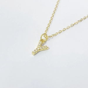 Macro shot of gold S925 silver Y-letter pendant necklace with shimmering cubic zirconia