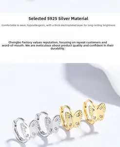 Détail de boucles d'oreilles papillon en argent 925 avec finitions or et argent