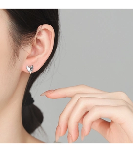 Gros plan de boucles d'oreilles papillon en argent 925 avec zircons sur le mannequin