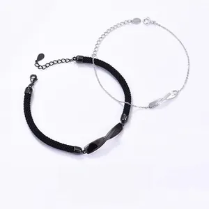 Detail of interlocking Mobius silver loops on black woven cord and delicate metal chain