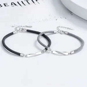 Detail of interwoven Mobius silver charms on braided ropes for couples with adjustable clasp