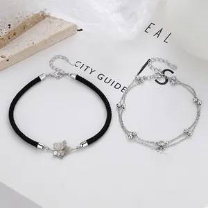 Detail of 925 sterling silver bead bracelet and black cord with maple leaf charms