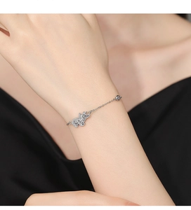 Detailed view of silver charm bracelet featuring a delicate elephant pendant and tiny diamonds