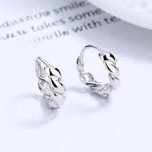 Macro detail of S925 sterling silver hoop earrings with classic twisted rope design