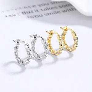 Detail of twisted hoop earrings with micro-pave crystals in gold and silver finish