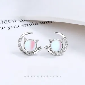 Detailed view of silver cat and crescent moon stud earrings with shimmering stones
