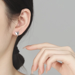 Élégantes boucles d'oreilles papillon en argent 925 avec zircones portées par un modèle