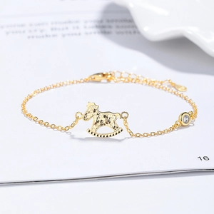 Golden rocking horse bracelet with sparkling cubic zirconia on a clean white background