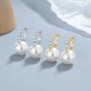 Detail view of S925 sterling silver stamp on gold and silver pearl hoop earrings