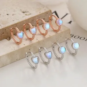 Detailed view of heart-shaped moonstone earrings with twisted rope metal design