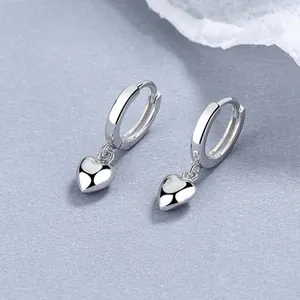 Macro shot of 925 sterling silver hoop earrings with solid black heart pendants