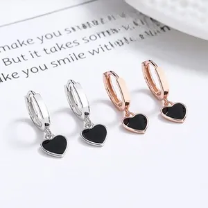 Detail of 925 silver and rose gold heart earrings with black enamel inlay
