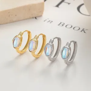 Macro view of sterling silver opal hoop earrings in gold and silver finish on stones