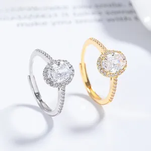 Macro shot of oval moissanite halo rings in silver and gold with side pavé diamonds