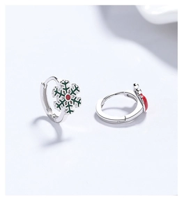 Detail of 925 sterling silver Christmas earrings with green enamel snowflake design