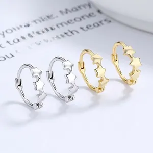 Close-up of gold and silver star embossed hoop earrings on a decorative white card