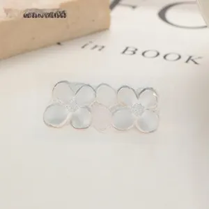 Detailed macro of matte 999 silver flower stud earrings on an elegant book background