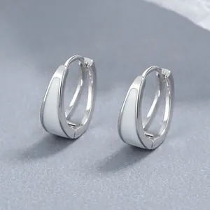 Dettaglio macro di orecchini a cerchio in argento a U con smalto bianco e design minimal