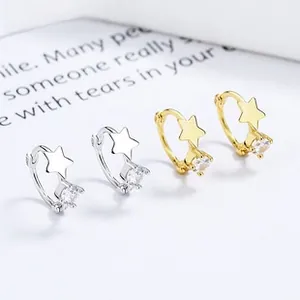 Macro shot of silver and gold star hoop earrings with round cubic zirconia settings