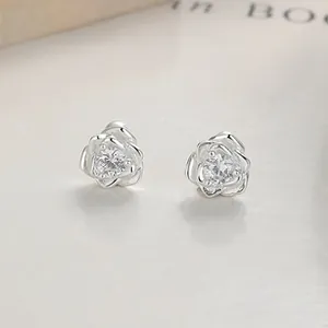 Detailed close-up of 999 silver rose earrings featuring a sparkling zircon center stone