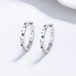 Macro shot of S925 silver hoop earrings featuring blue zircon and celestial star moon patterns