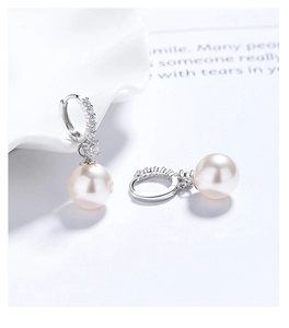 Detailed close-up of 925 silver pearl drop earrings with sparkling cubic zirconia inlay