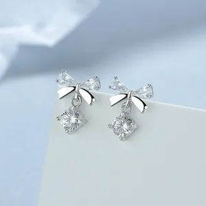 Macro shot of 999 silver bow earrings with zircon stones on a white display card