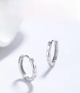 Detail of S925 sterling silver hoop earrings with star motifs and zircon stones