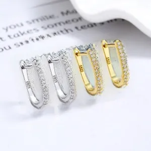 Detail of silver and gold U-shaped S925 sterling silver hoop earrings with pavé diamonds
