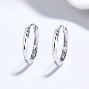 Close-up of minimalist silver hoop earrings featuring a polished finish and latch clasp