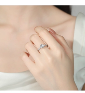 Close-up of a 925 sterling silver ring featuring a six-prong moissanite setting and side diamonds