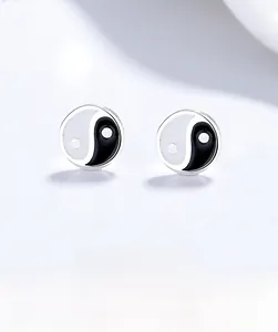 Macro view of sterling silver Yin Yang stud earrings with polished drip glue finish