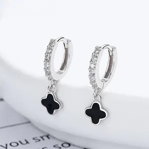 Detailed macro view of S925 silver hoop earrings with black clover charms and zircon stones