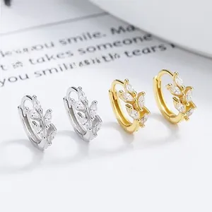 Detail view of silver and gold leaf hoop earrings with marquise cubic zirconia stones