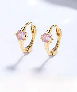 Macro shot of S925 sterling silver stamp and pink heart zircon on gold-plated earrings