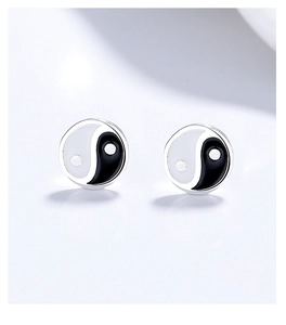 Macro shot of 999 silver Tai Chi Bagua stud earrings with black and white enamel finish