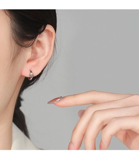 Close-up of S925 silver hollow drop earrings with zircon on woman's earlobe