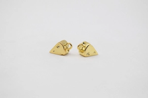 Macro detail of gold-plated cheese charms with realistic hole textures for DIY jewelry