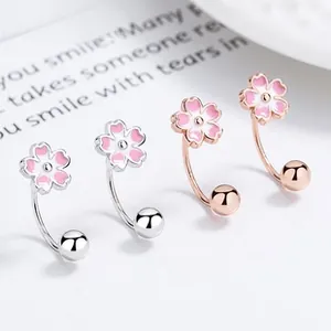 Detail of 925 silver and rose gold cherry blossom U-shaped earrings with pink enamel