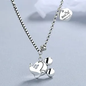 Macro shot of silver Mickey charm with Love Forever engraving on a layered chain