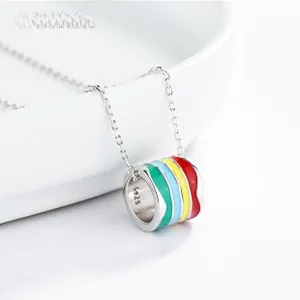 Macro shot of S925 sterling silver cylinder pendant with colorful enamel stripes on a plate