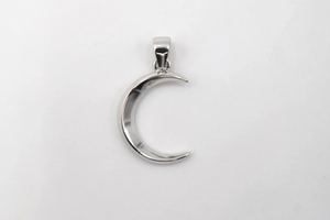 Macro detail of a crescent moon pendant in polished S925 sterling silver with a mirror finish