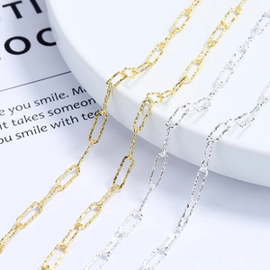 Detail of gold and silver textured rectangle link chains with shimmering diamond-cut finish